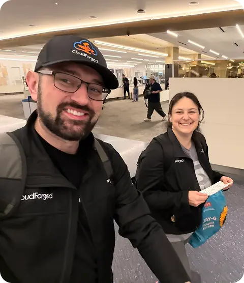 Two team members in CloudForged gear on their way through an airport
